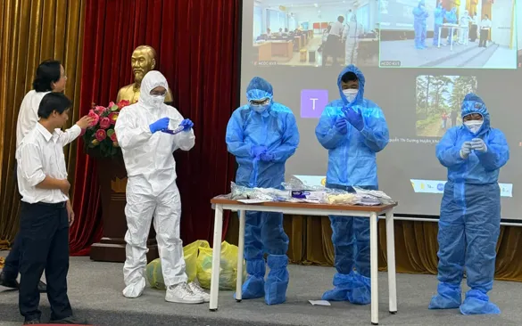 Thành viên Đội đáp ứng nhanh (RRT) được hướng dẫn sử dụng đúng cách phương tiện phòng hộ cá nhân (PPE). Ảnh: HCDC