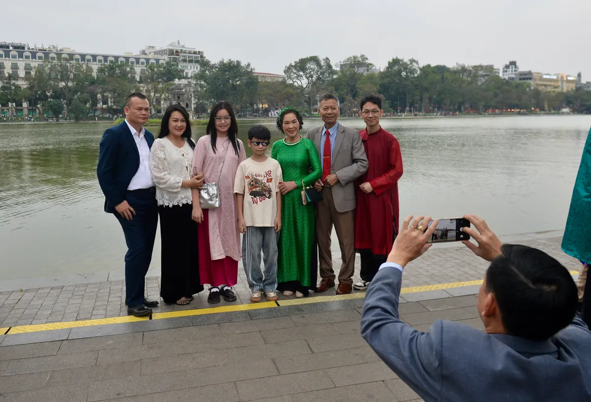 Người dân háo hức đổ về Hồ Gươm chờ khoảnh khắc pháo hoa đêm Giao thừa - Ảnh 2.