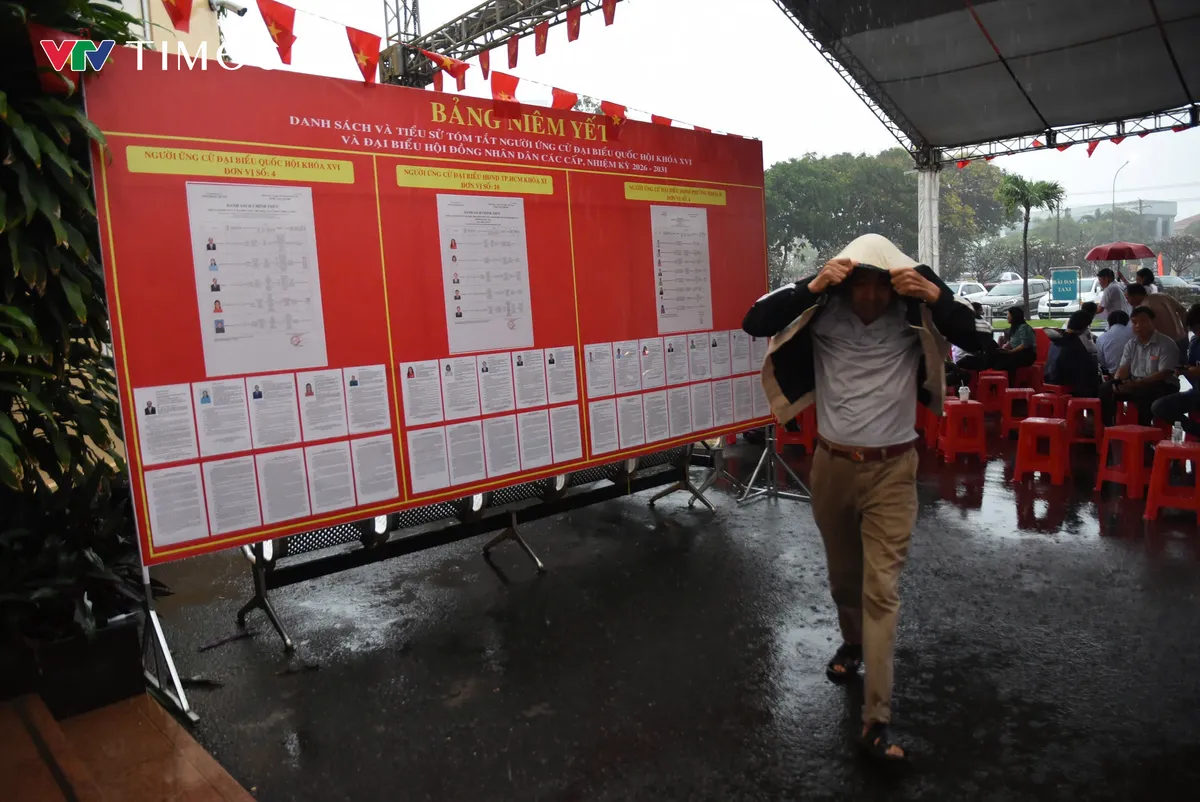 Cử tri TP Hồ Ch&iacute; Minh &ldquo;đội mưa&rdquo; đi bầu cử sớm  - Ảnh 1.