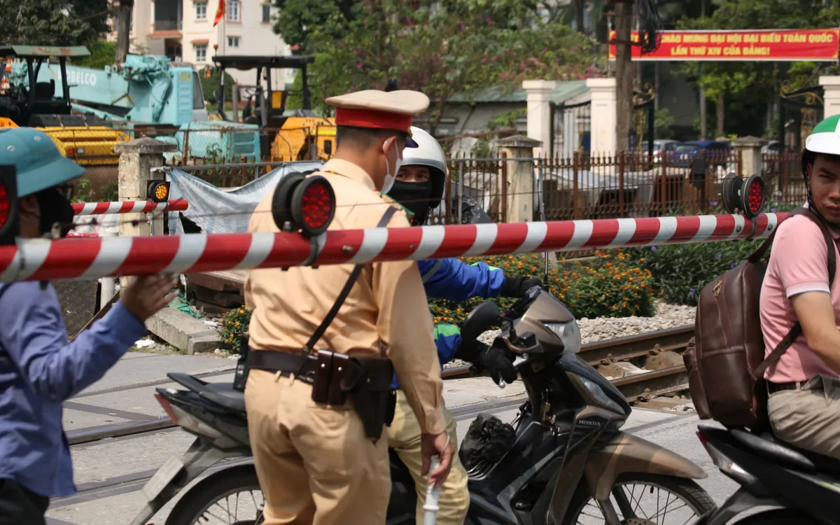 CSGT và nhân viên gác chắn "giải cứu" shiper mắc kẹt khi cố vượt rào chắn đường ngang.