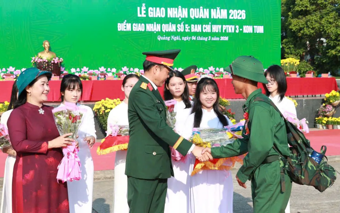 Đại tá Trần Anh Tuấn, Phó Chủ nhiệm Chính trị Quân khu tặng hoa chúc mừng thanh niên lên đường nhập ngũ.