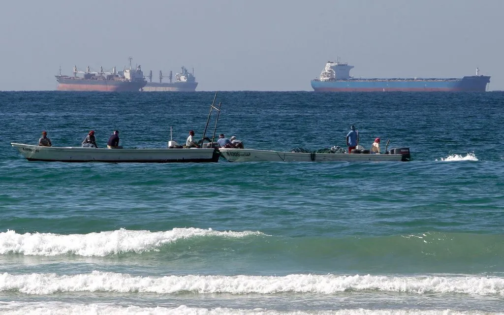 Ngư dân đánh bắt cá phía trước các tàu chở dầu ở phía Nam eo biển Hormuz (Ảnh: AP)