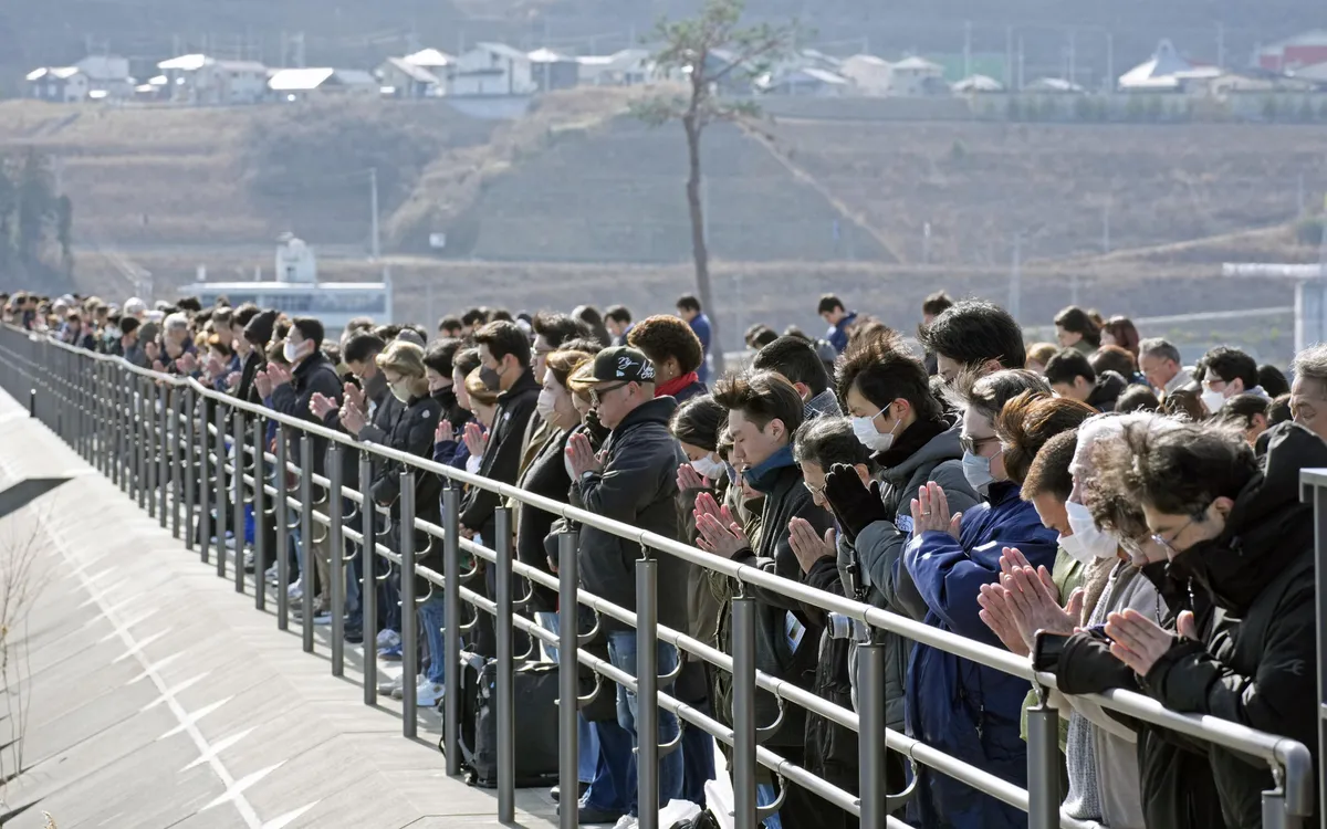 Người dân cầu nguyện trên con đê chắn sóng ở Miyako, tỉnh Iwate, Nhật Bản, ngày 11/3, tưởng niệm 15 năm thảm họa động đất - sóng thần (Ảnh: AP)