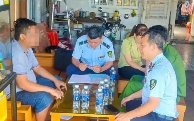 Lực lượng Quản lý thị trường thành phố Cần Thơ làm việc với một cửa hàng xăng dầu sau khi người dân phản ánh. (Ảnh: TTXVN) 