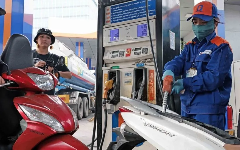 Khách hàng mua bán xăng, dầu tại một điểm kinh doanh xăng dầu của Petrolimex trên địa bàn Hà Nội. (Ảnh: Trần Việt /TTXVN)