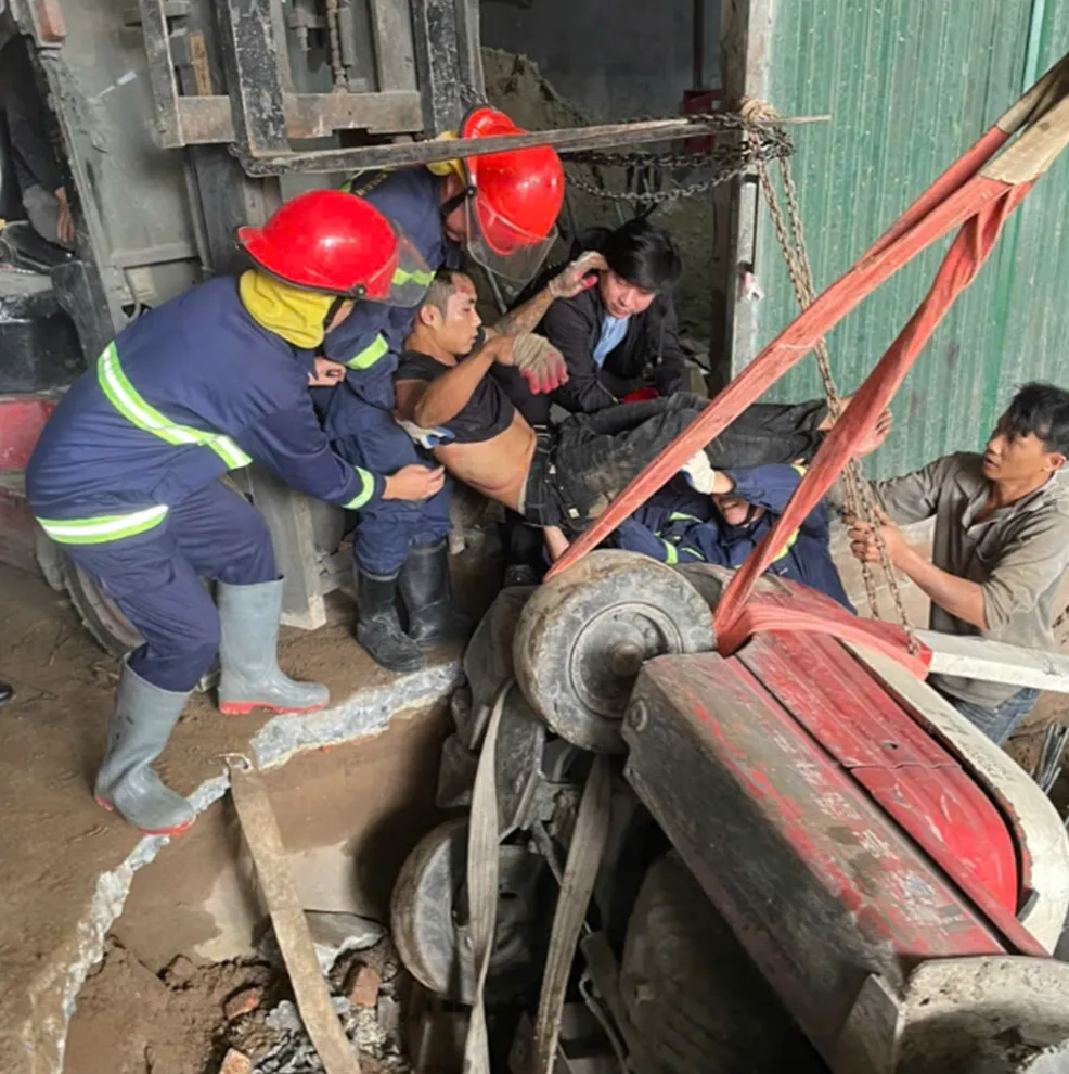 7 ph&uacute;t căng thẳng cứu c&ocirc;ng nh&acirc;n bị xe n&acirc;ng đ&egrave; l&ecirc;n người - Ảnh 1.