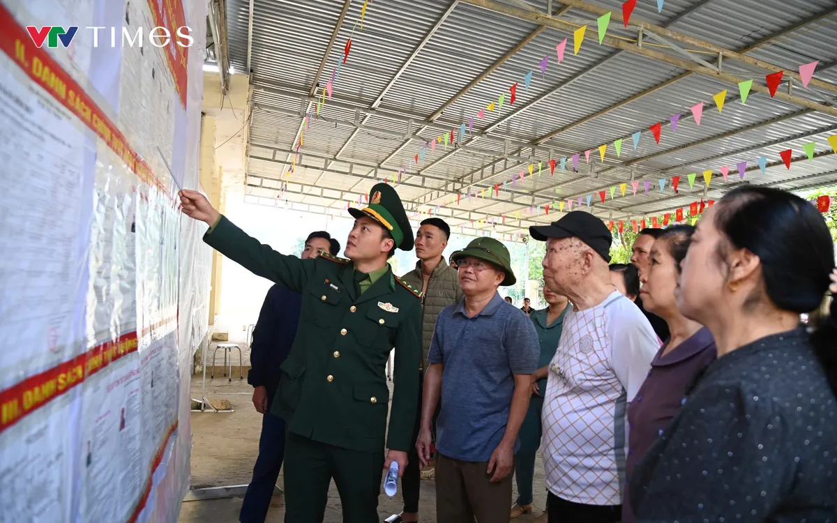 Cán bộ đồn Biên phòng cửa khẩu Ma Lù Thàng BĐBP Lai Châu hướng dẫn nhân dân bản Pa Nậm Cúm, xã Phong Thổ tìm hiểu tiểu sử các các đại biểu tham gia ứng cử..Ảnh: Đức Duẩn