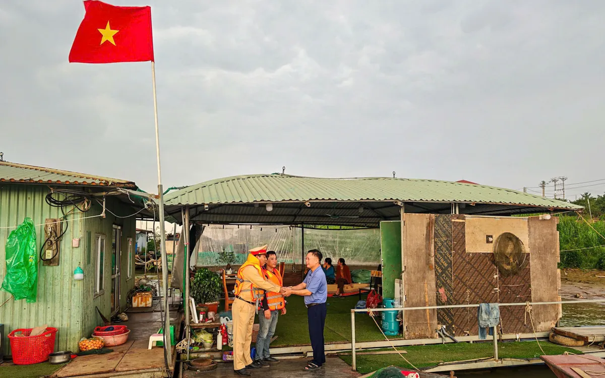 Cảnh sát đường thuỷ cùng cán bộ xã đến các xóm chài tuyên truyền về bầu cử và phát thẻ cử tri.