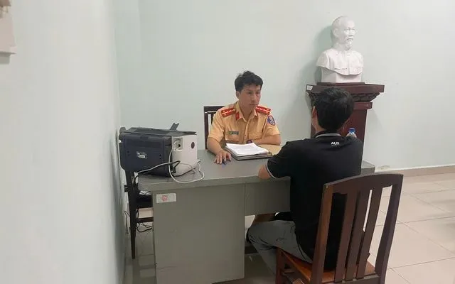 Cán bộ Phòng CSGT làm việc với ông D.T.Q - Ảnh: PC08