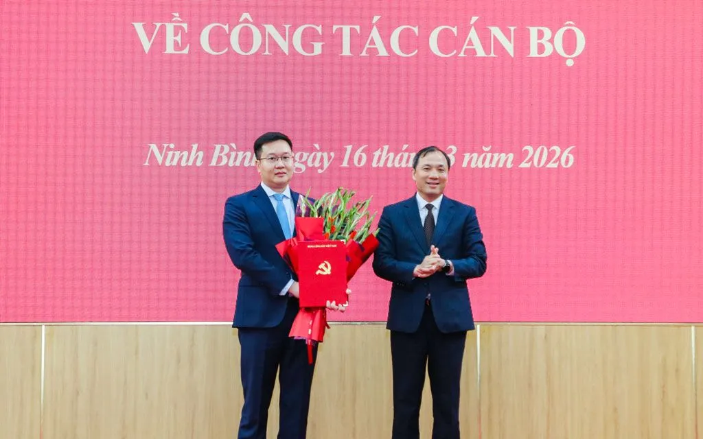 Đồng chí Phó Trưởng Ban Thường trực Ban Tổ chức Trung ương Hoàng Trung Dũng trao Quyết định của Bộ Chính trị, tặng hoa chúc mừng đồng chí Phó Bí thư Tỉnh ủy Ninh Bình Trần Đăng Quỳnh.