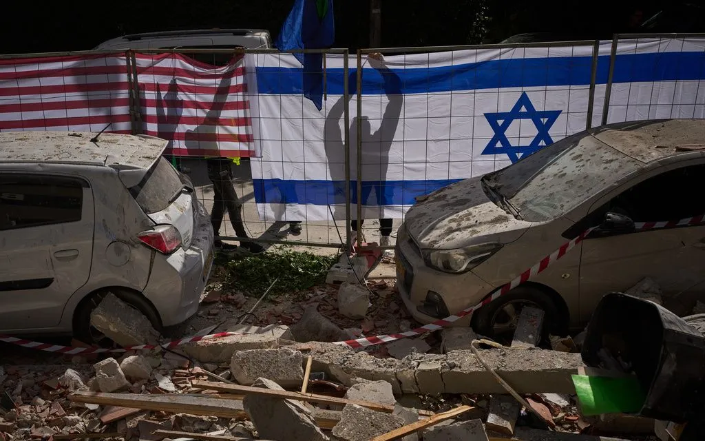 Chính quyền Israel treo cờ Israel và Mỹ tại địa điểm bị trúng tên lửa của Iran ở Ramat Gan, Israel, ngày 18/3/2026 (Ảnh: AP)