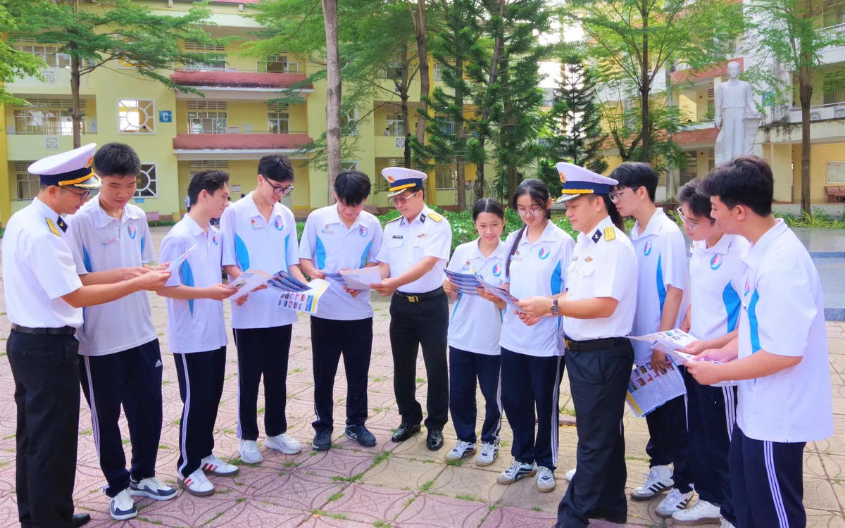 Cán bộ Học viện Hải quân trao đổi, chia sẻ, cung cấp thông tin trong tờ rơi về công tác tuyển sinh vào Học viện Hải quân năm 2026.