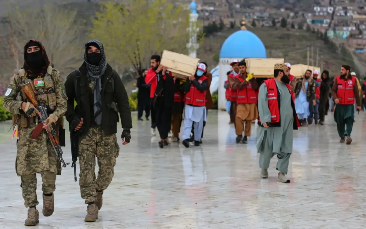 Lực lượng an ninh Taliban canh gác khi người dân khiêng thi hài các nạn nhân vụ không kích hôm 16/3 vào một bệnh viện cai nghiện ma túy, trước lễ an táng hôm 18/3/2026 tại Kabul, Afghanistan (Ảnh: AP)