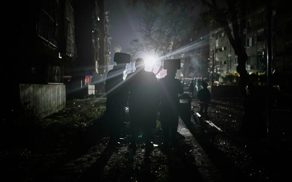 Lực lượng an ninh và cứu hộ Israel tại địa điểm bị trúng tên lửa của Iran ở thành phố Arad, miền Nam Israel, ngày 22/3/2026 (Ảnh: AP)