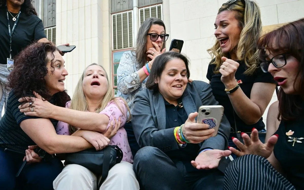 Luật sư Laura Marquez-Garrett (áo vest xám, thứ 3 từ phải sang) cùng gia đình các nạn nhân phản ứng sau khi bồi thẩm đoàn tuyên Meta và YouTube phải chịu trách nhiệm, bên ngoài Tòa án Thượng thẩm Los Angeles ngày 25/3/2026 (Ảnh: FREDERIC J. BROWN/AFP)