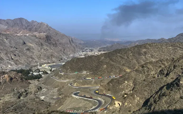 Khói bốc lên từ phía Afghanistan khi các xe tải đậu dọc đường sau các cuộc đụng độ xuyên biên giới giữa lực lượng Pakistan và Afghanistan, gần cửa khẩu Torkham, Pakistan, ngày 28/2/2026 (Ảnh: AP)