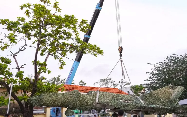 Chiếc máy bay tiêm kích MiG-21 được di dời thành công từ vị trí cũ tại đường Nguyễn Trãi, phường An Xuyên, về trụ sở Bộ Chỉ huy Quân sự tỉnh Cà Mau, đường 3/2, phường Tân Thành. (Ảnh: TTXVN)