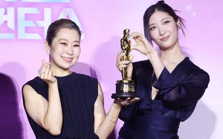 Đạo diễn Maggie Kang (bên trái) và ca sĩ kiêm nhạc sĩ EJAE tạo dáng cùng giải thưởng Oscar trong một buổi họp báo ở Seoul hôm thứ Tư. (Ảnh: Yonhap)