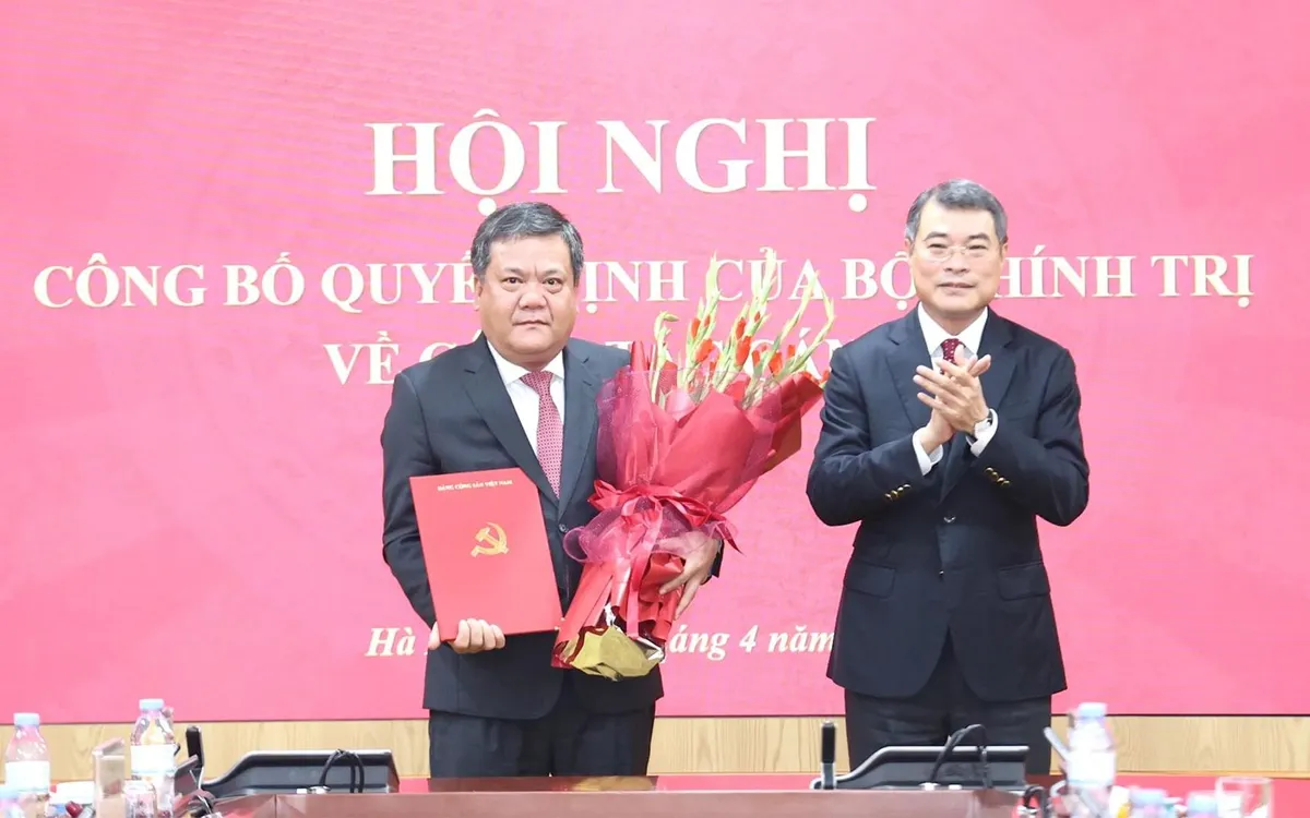 Đồng chí Lê Minh Hưng trao quyết định và tặng hoa chúc mừng đồng chí Trần Phong. Ảnh: Báo Khánh Hòa điện tử