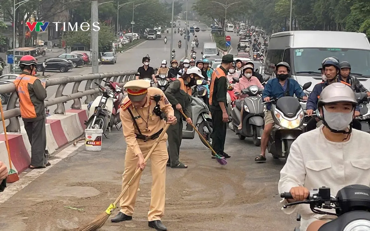 Cảnh sát và nhân viên Ban quản lý cầu dùng cát khô khắc phục sự cố.