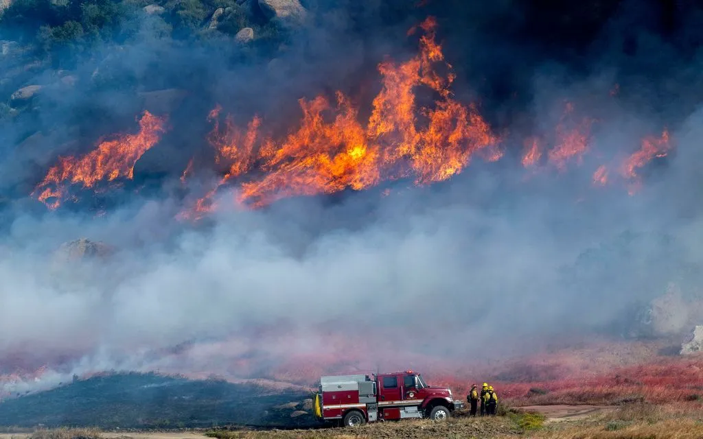 Lính cứu hỏa theo dõi đám cháy rừng Springs Fire lan nhanh, nhiều khói tại Moreno Valley, California, ngày 3/4/2026. (Ảnh AP)