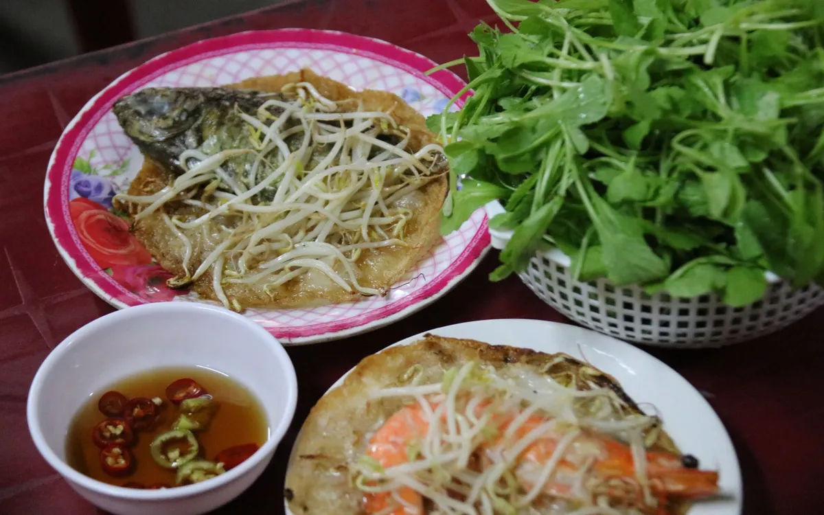 Bánh khoái cá kình làng Chuồn không chỉ để ăn, mà để trải nghiệm: từ chọn cá nơi chợ sớm đến chờ bánh xèo trên bếp lửa. Cái ngon nằm ở sự tươi rói của đầm phá và nhịp sống chậm rãi của một làng quê xứ Huế. 