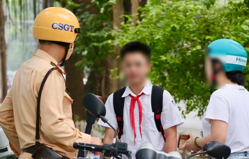 Hà Nội: Xử phạt nhiều phụ huynh không đội mũ bảo hiểm cho con khi đi xe máy - Ảnh 2.