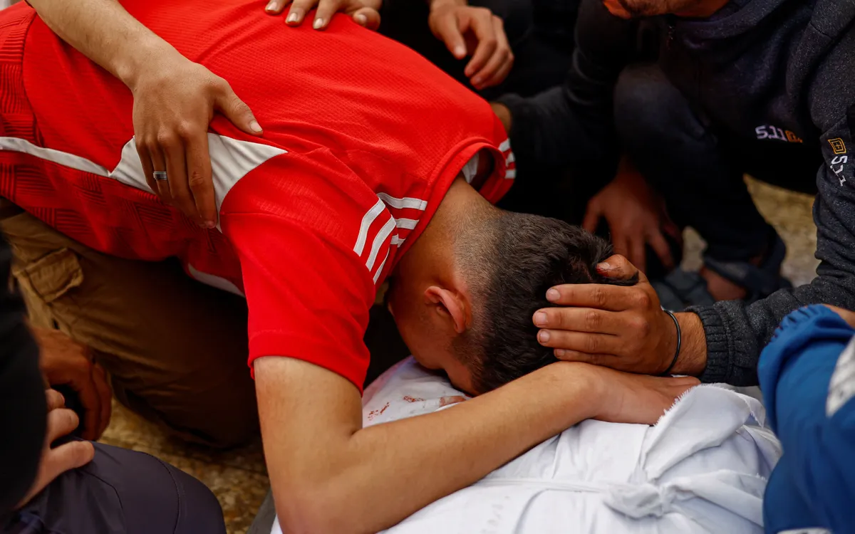 Người thân bên thi thể ông Majdi Aslan tại Bệnh viện Al-Aqsa Martyrs, Deir al-Balah, Gaza, ngày 6/4/2026. (Ảnh: REUTERS)