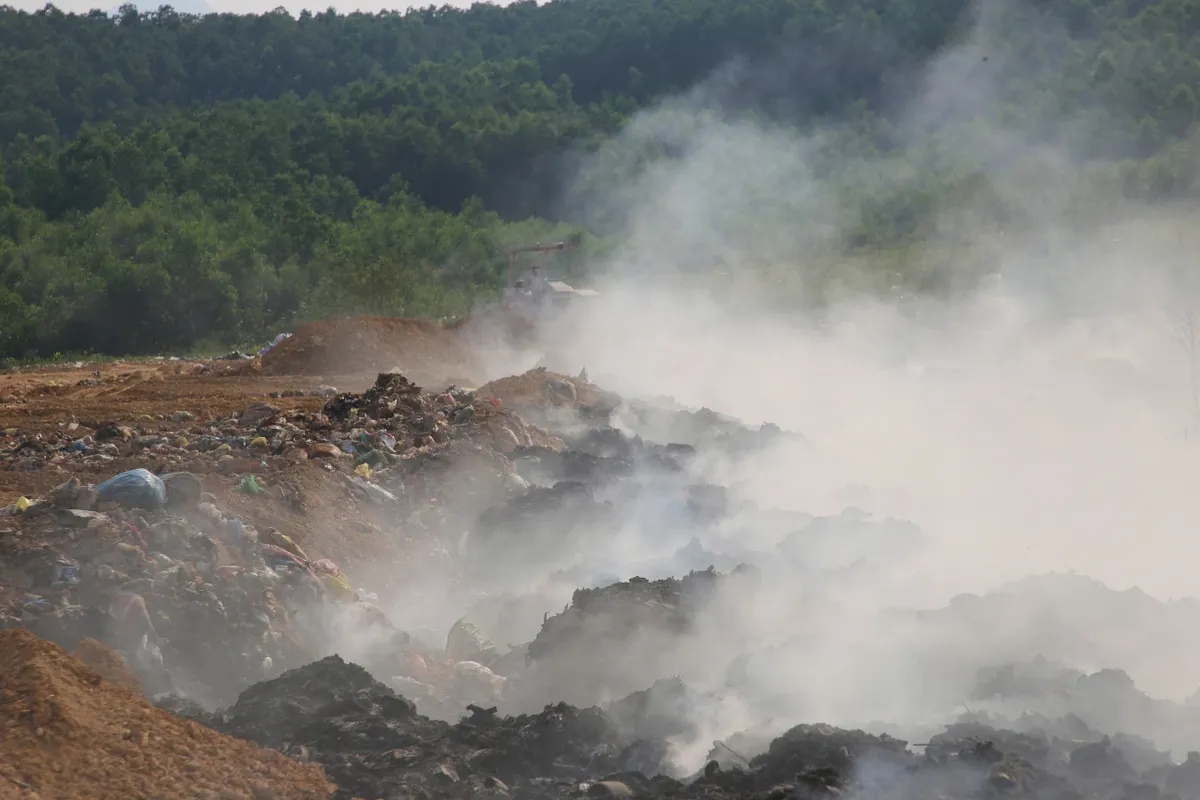 Cháy bãi rác kéo dài, người dân sống trong khói và mùi hôi - Ảnh 1.