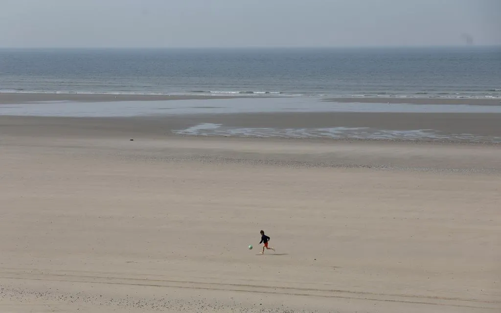 Một bé trai chạy trên bãi biển Equihen-Plage, nơi xảy ra vụ 4 người thiệt mạng khi tìm cách vượt eo biển Anh, ngày 9/4/2026. (Ảnh: AP)