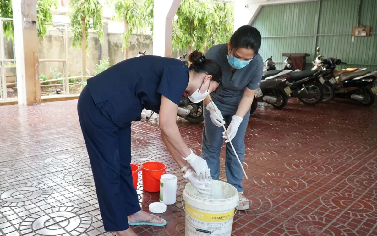 Trạm Y tế phường Buôn Ma Thuột hướng dẫn nhà trường cách pha dung dịch và vệ sinh bề mặt tại lớp học cũng như nơi ở. Ảnh: Sở Y tế Đắk Lắk