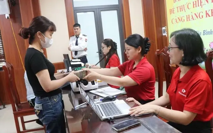 Các hộ dân đến nhận tiền thưởng do bàn giao mặt bằng sớm Dự án Cảng hàng không Quốc tế Gia Bình. (Ảnh: Thanh Thương/ TTXVN)