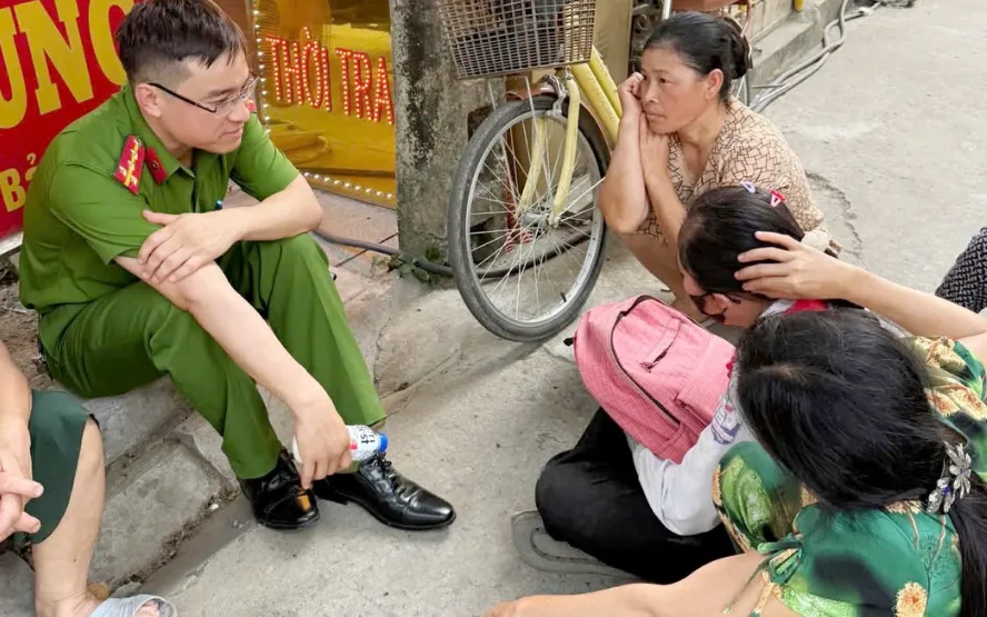 Đại úy Ngô Giáp Đồng, cán bộ Cảnh sát khu vực, Công an xã Vĩnh Lộc và người dân trên địa bàn trấn an tinh thần cháu bé