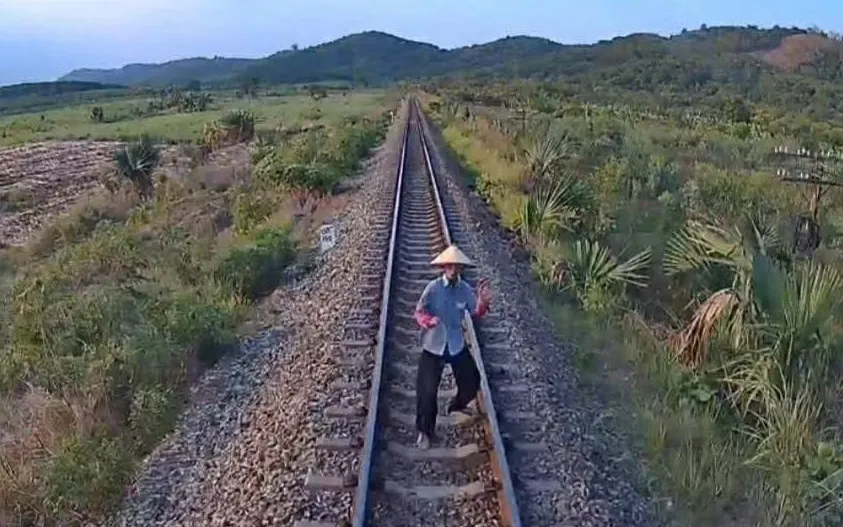 Camera tàu hỏa ghi lại hình ảnh người phụ nữ đứng giữa đường ray.