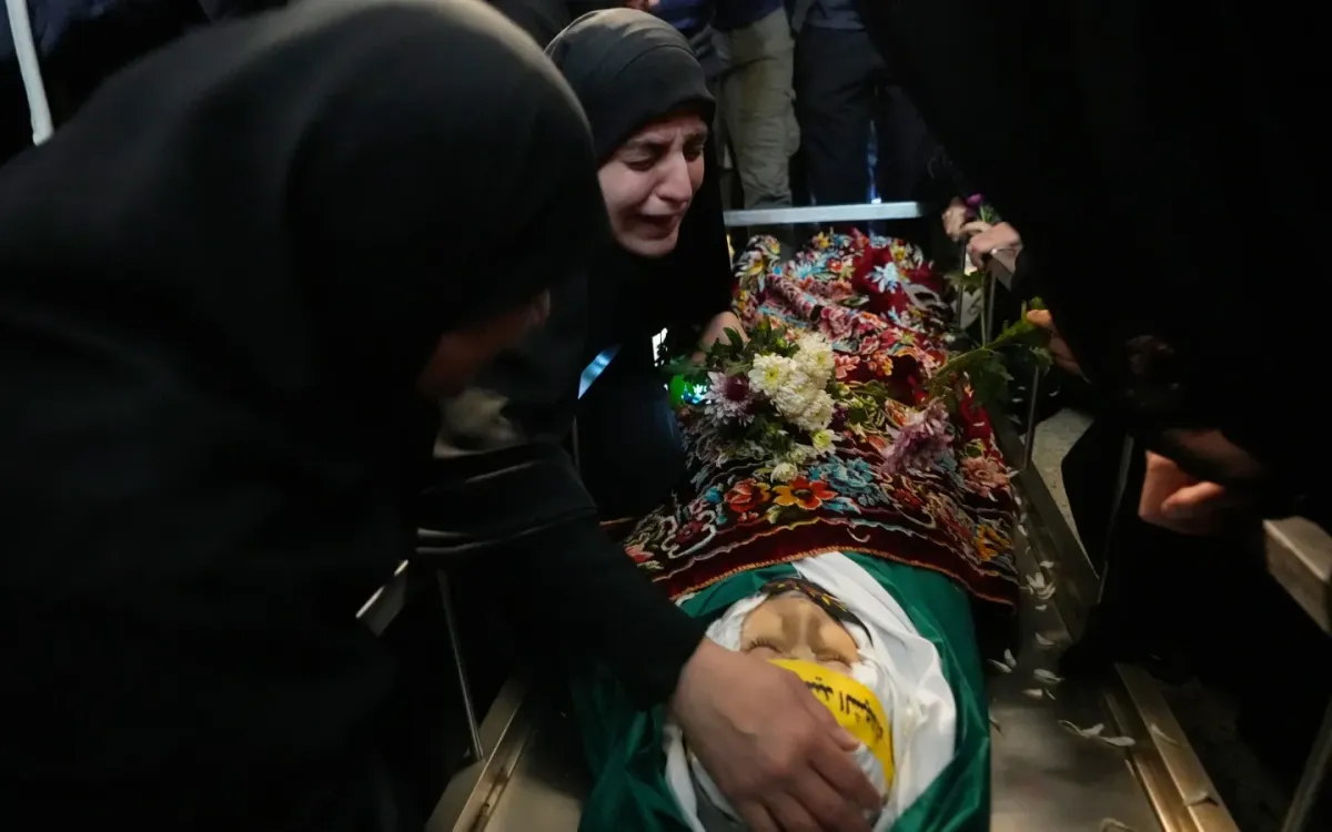 Malak Meslmani (giữa) đau buồn bên thi thể con trai Jawad Younes, 11 tuổi, trong lễ tang tại làng Saksakieh, Nam Lebanon, ngày 28/3/2026. (Ảnh: AP)