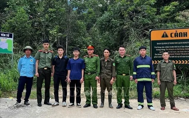 Hai du khách (3 và 4 từ trái qua) chụp ảnh với lực lượng tham gia tìm kiếm. Ảnh: TTXVN