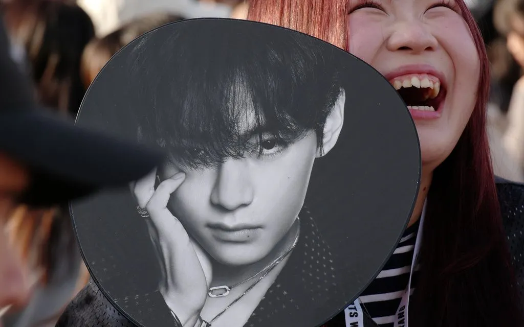 Một fan K-pop mỉm cười trước buổi concert thuộc tour diễn thế giới của BTS bên ngoài Tokyo Dome vào thứ Sáu, ngày 17/4 tại Tokyo. (Ảnh: AP/Eugene Hoshiko)
