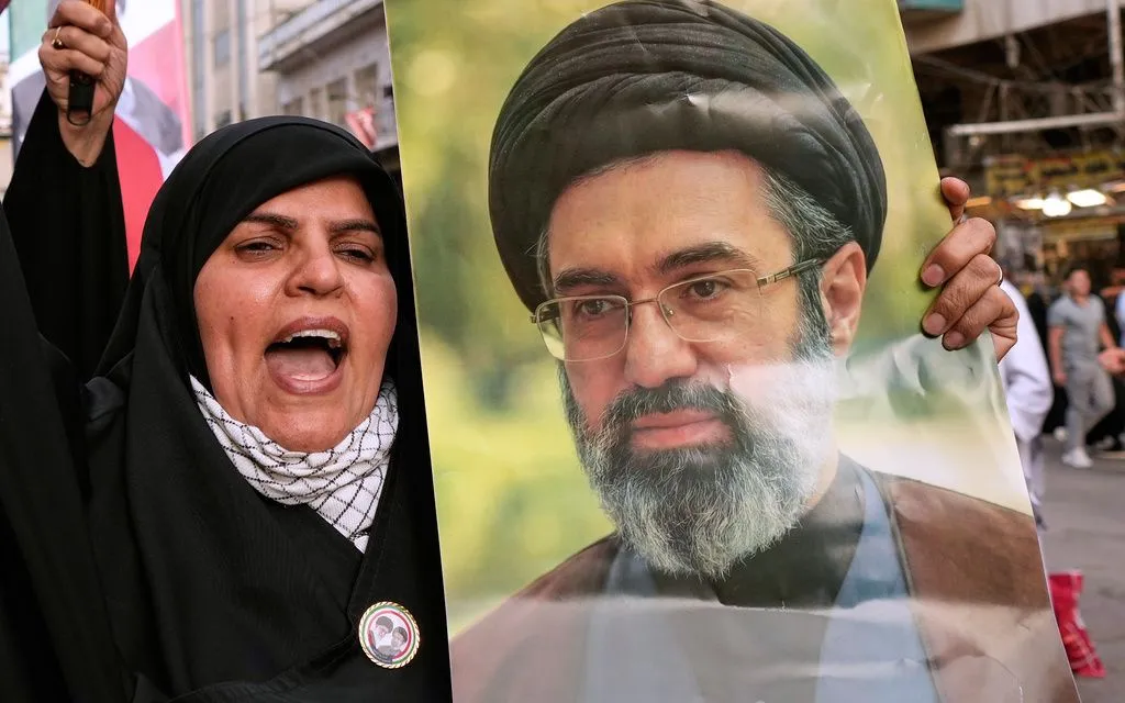 Người phụ nữ cầm ảnh chân dung của Lãnh tụ tối cao Iran Ayatollah Mojtaba Khamenei trong một cuộc biểu tình phản đối các cuộc tấn công của Mỹ và Israel (Ảnh: AP)