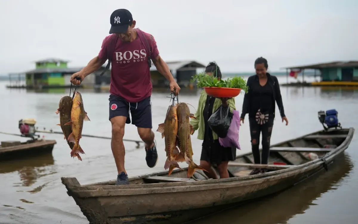 Một người đàn ông dỡ cá tươi từ thuyền trên sông Amazon ở Puerto Narino, Colombia, ngày 7/9/2025. (Ảnh: AP)