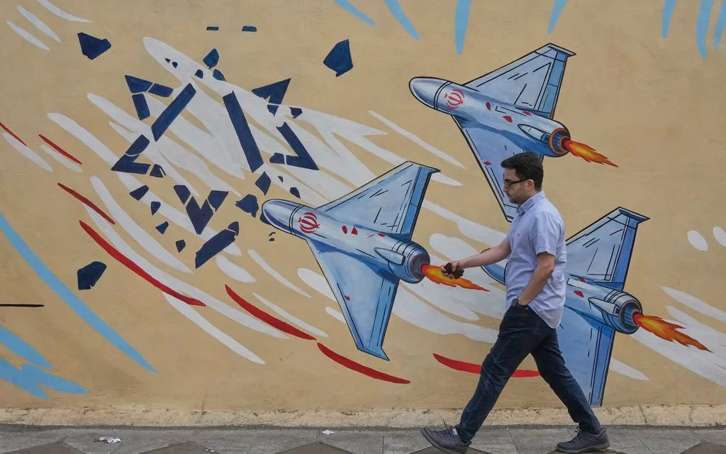 Một người đàn ông đi ngang qua bức tranh tường cổ động chống Israel ở trung tâm Tehran, Iran, ngày 17/5/2026 (Ảnh minh họa: AP)