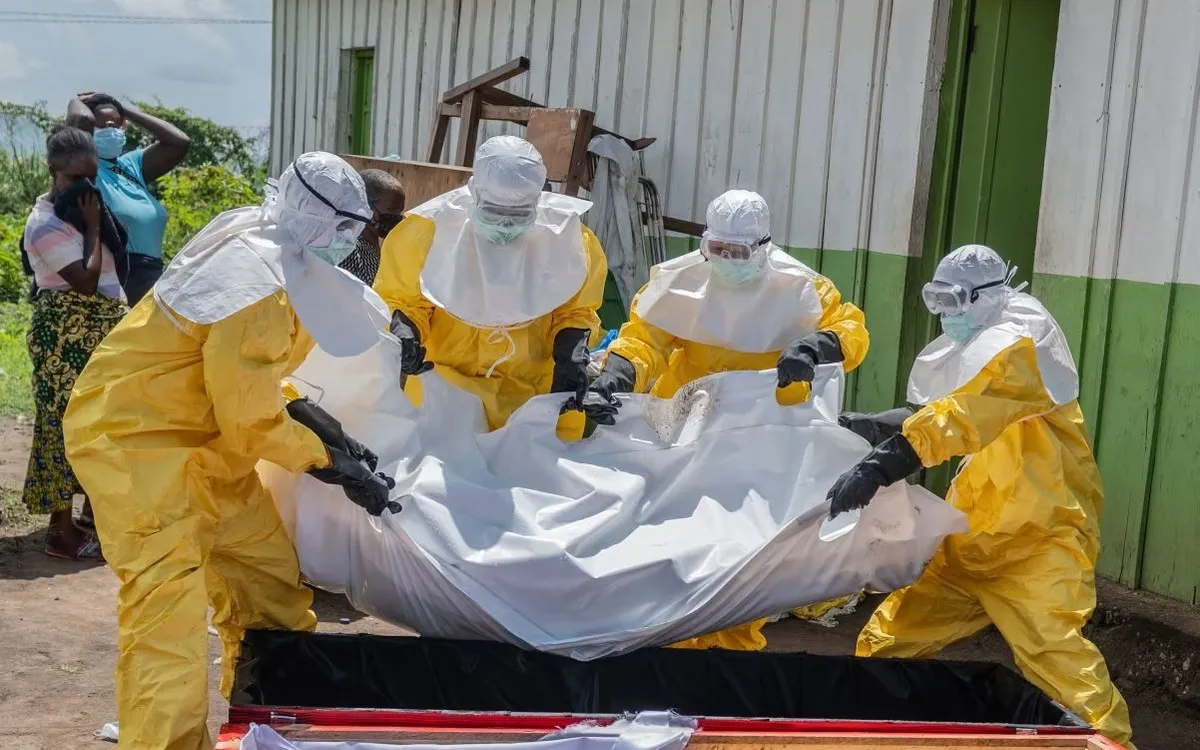 Nhân viên Hội Chữ thập đỏ đưa thi thể một người tử vong vì Ebola vào quan tài tại Rwampara, Cộng hòa Dân chủ Congo. (Ảnh: AP)