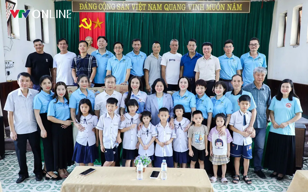 Các đại biểu cùng các nhà báo, phóng viên trao những phần quà ý nghĩa tới trẻ em tại Làng trẻ em SOS.
