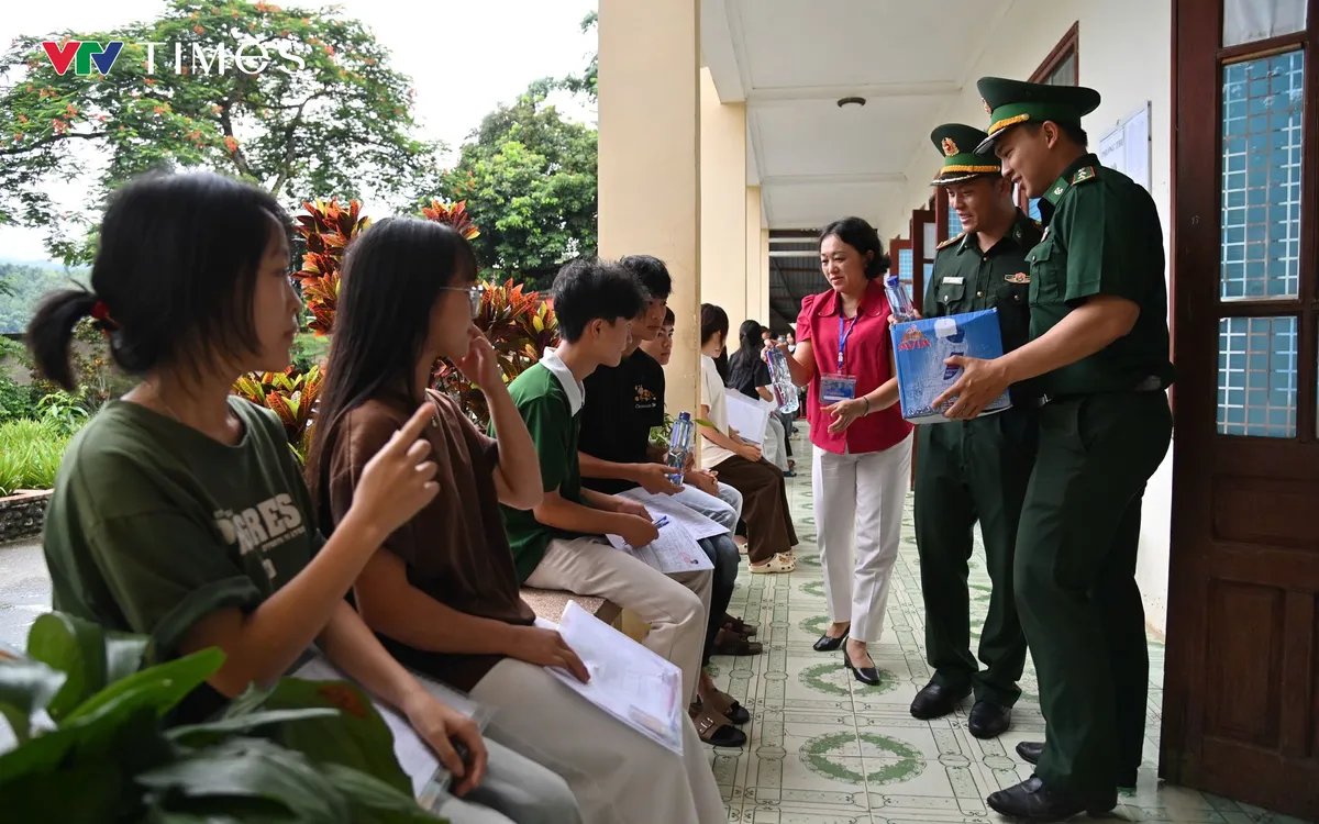 Cán bộ, chiến sĩ Đồn Biên phòng cửa khẩu Ma Lù Thàng tiếp sức các sĩ tử tại điểm thi Trường THPT Phong Thổ trước giờ làm thủ tục dự thi. Ảnh: Đức Duẩn
