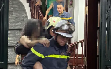 Lực lượng chức năng giải cứu người mắc kẹt an toàn ra khỏi đám cháy. (ảnh: Công an Hà Nội)