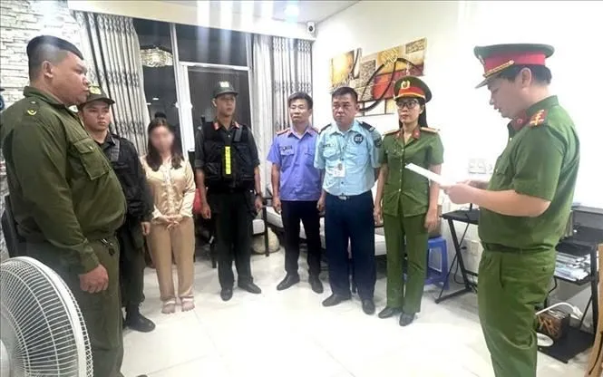 Cơ quan cảnh sát điều tra Công an thành phố Đồng Nai thi hành lệnh khám xét khẩn cấp đối tượng Trần Thị Thu Hà. Ảnh: TTXVN