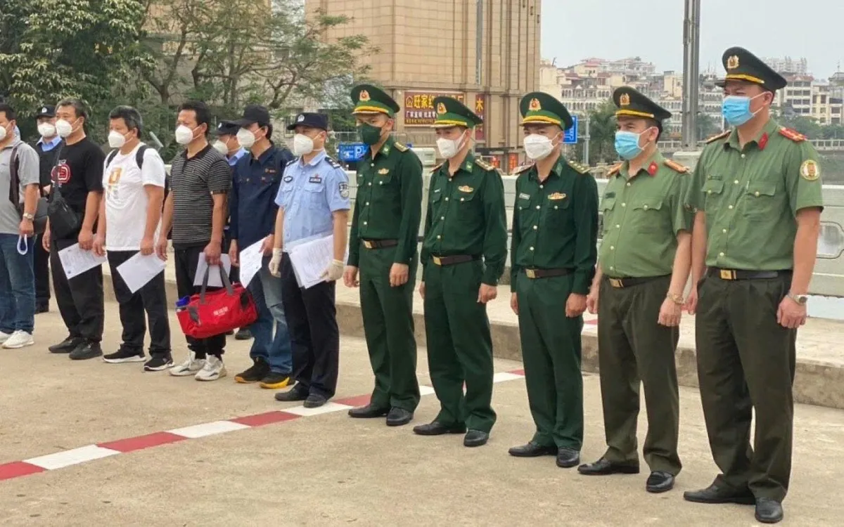 Cơ quan chức năng bàn giao, tiếp nhận công dân xuất cảnh trái phép bị trục xuất - Ảnh: BCA