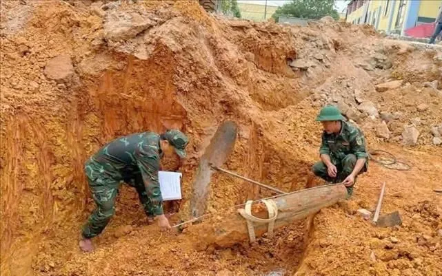 Quả bom nằm sâu dưới đất khoảng 2,5m được phát hiện khi công nhân đào móng xây dựng Trường Tiểu học Lưu Sơn, xã Đô Lương. Ảnh: TTXVN 
