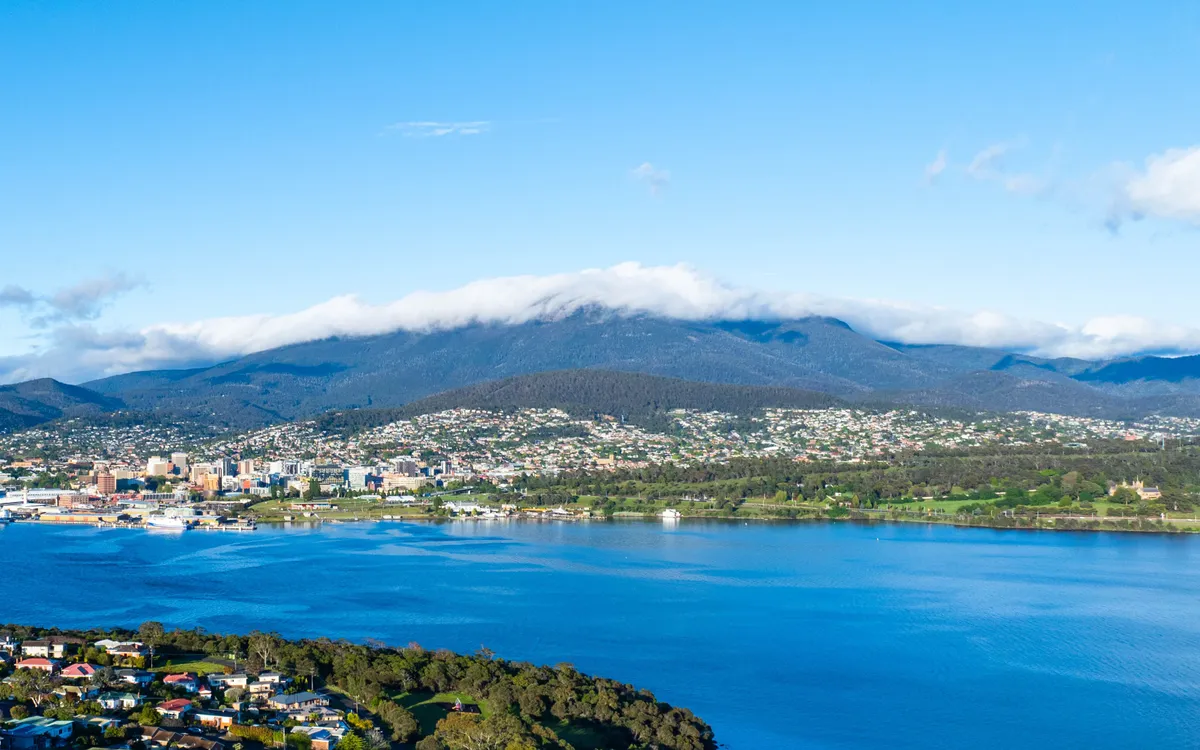 Nhìn từ phía thành phố, Mount Wellington sừng sững như một bức tường thành ôm trọn lấy Hobart. Đỉnh núi thường xuyên được bao phủ bởi những dải mây trắng bồng bềnh trôi ngang..