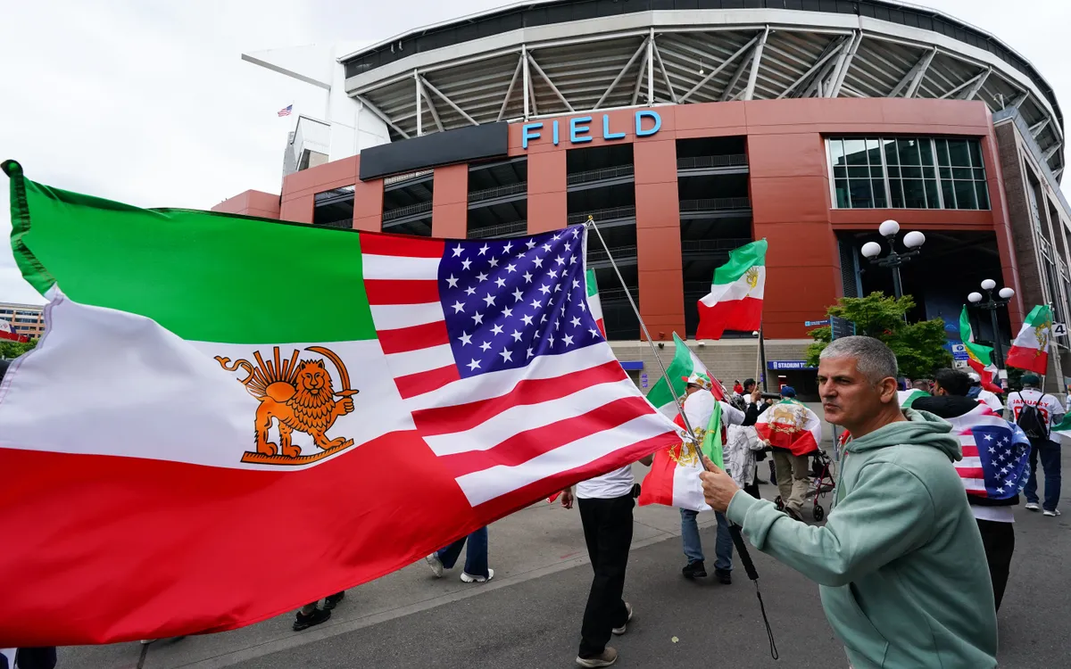 Người đàn ông cầm cờ Mỹ - Iran bên ngoài sân vận động ở Seattle, Mỹ, ngày 26/6/2026 (Ảnh minh họa: AP)