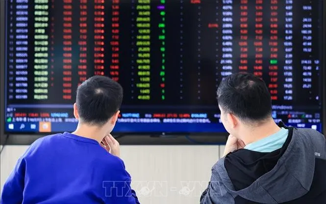 Nhà đầu tư theo dõi chỉ số chứng khoán tại tỉnh Giang Tô, Trung Quốc. Ảnh: THX/TTXVN